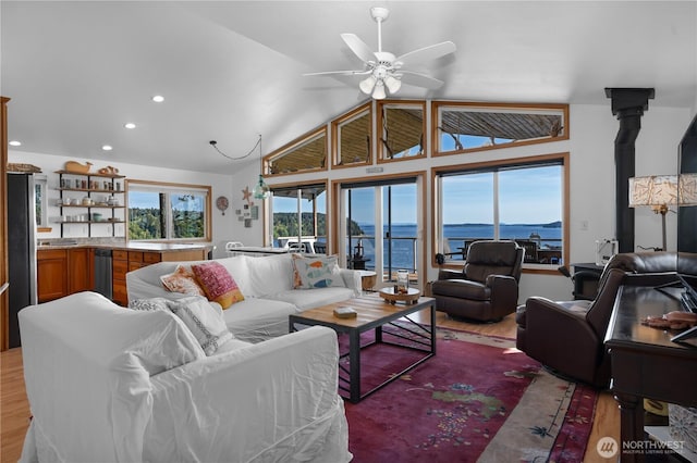 living room with light wood-type flooring, vaulted ceiling, and a ceiling fan