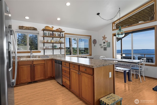 kitchen with a wealth of natural light, appliances with stainless steel finishes, brown cabinets, and a sink