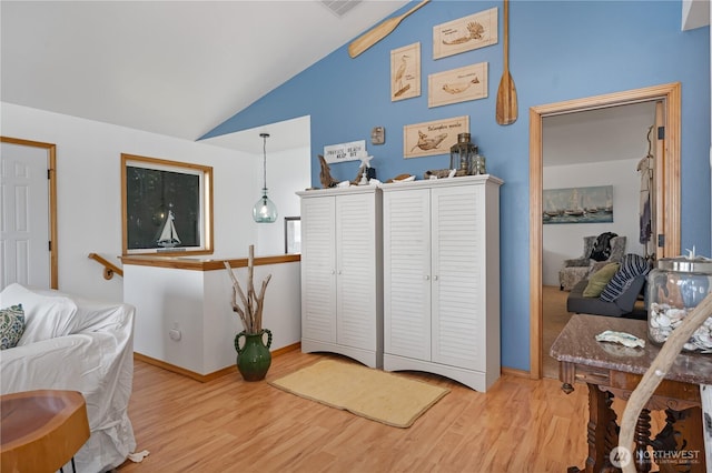 sitting room featuring baseboards, vaulted ceiling, and wood finished floors