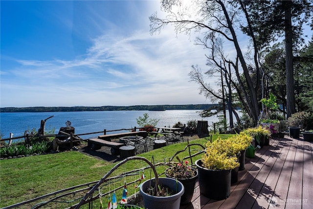 wooden deck featuring a water view and a lawn