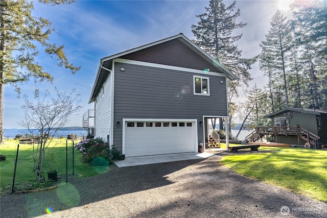 view of home's exterior with stairs, a yard, driveway, and a garage