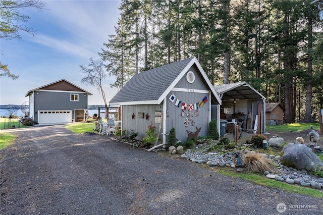 garage with a carport and gravel driveway