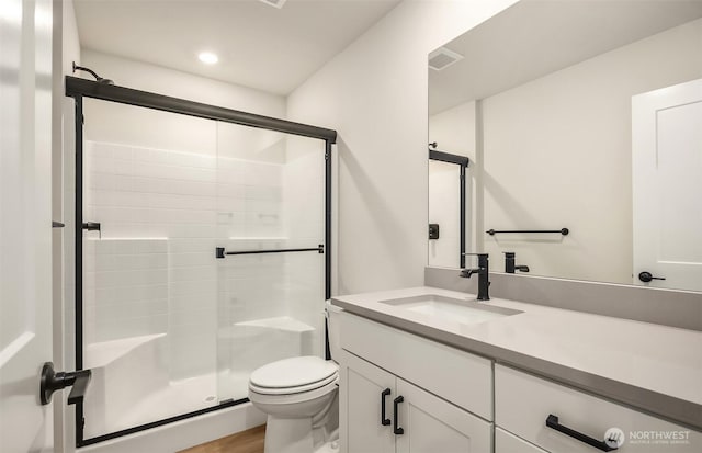 bathroom featuring a stall shower, vanity, toilet, and recessed lighting