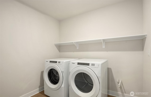 clothes washing area with laundry area, baseboards, and washer and dryer