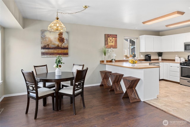 dining area featuring baseboards and wood finished floors