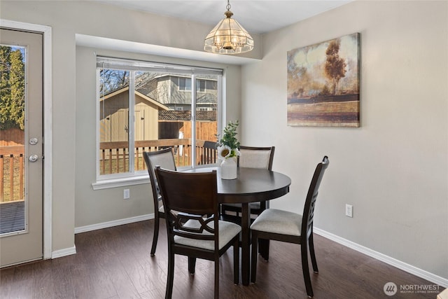 dining room featuring an inviting chandelier, wood finished floors, and baseboards