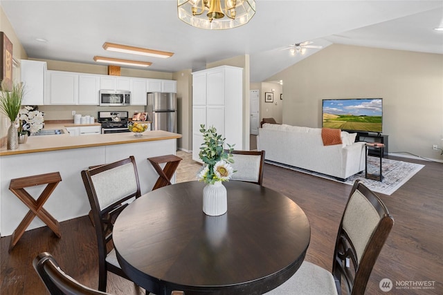 dining room featuring lofted ceiling, wood finished floors, and a ceiling fan