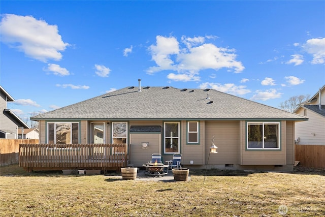 back of property with a fire pit, fence, crawl space, a lawn, and a wooden deck