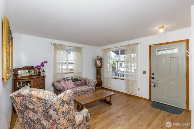 living area featuring baseboards and light wood finished floors