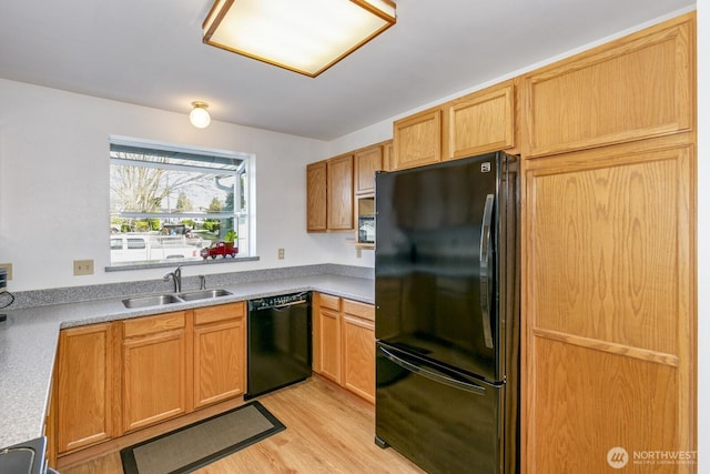 kitchen with black appliances, light wood-style floors, a sink, and light countertops