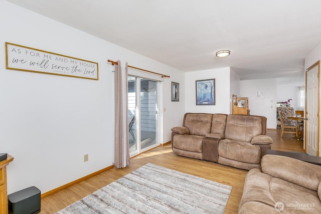 living area with a wealth of natural light, light wood-style flooring, and baseboards