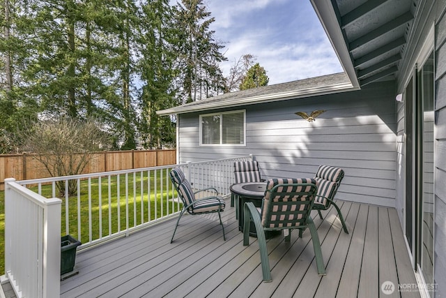 deck with a lawn and fence