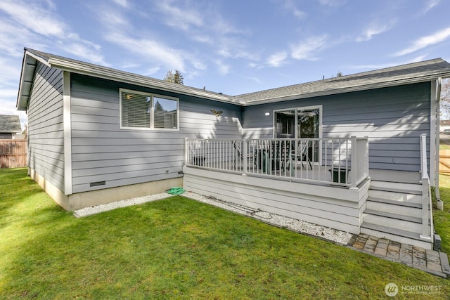 rear view of house with crawl space, a lawn, and fence