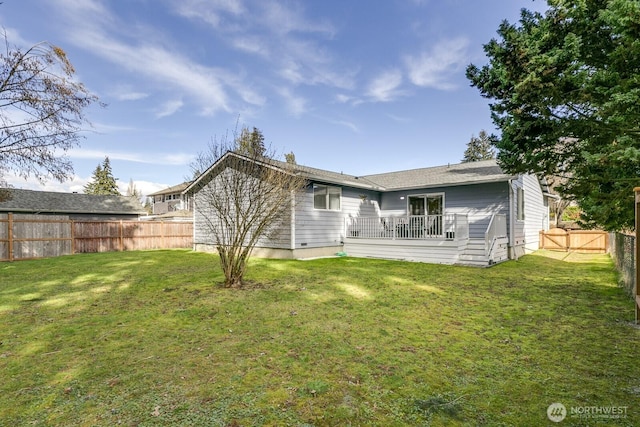 back of house with a lawn and a fenced backyard