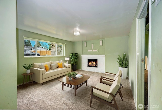 living room featuring carpet floors and a lit fireplace