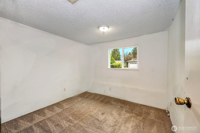 unfurnished room with a textured ceiling and carpet floors