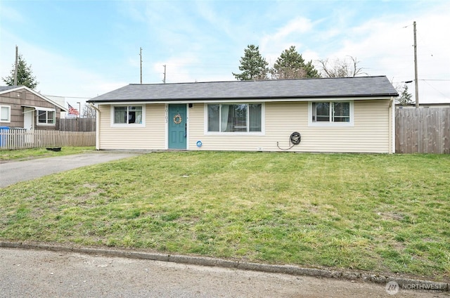 single story home featuring aphalt driveway, fence, and a front lawn