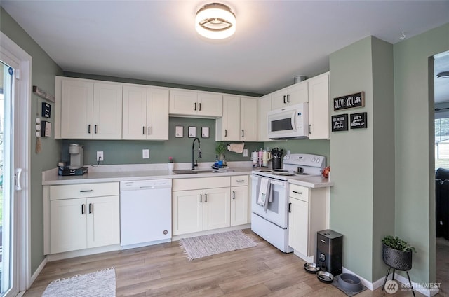 10103 Kline St SW, Lakewood, WA 98499 - kitchen featuring white appliances, a sink, white cabinetry, light wood-style floors, and light countertops