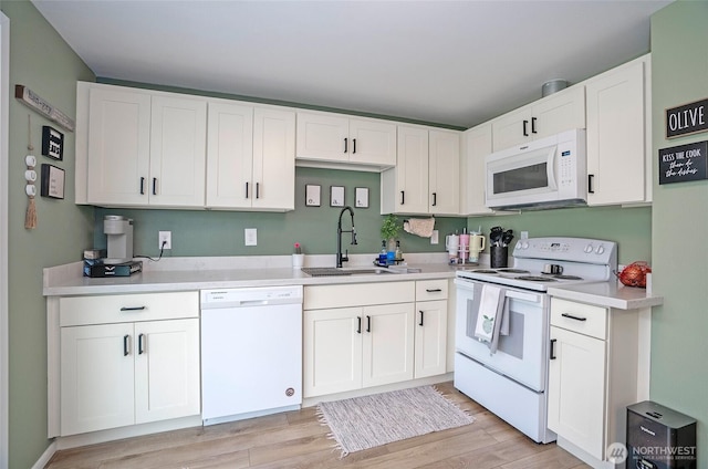 10103 Kline St SW, Lakewood, WA 98499 - kitchen featuring white appliances, light countertops, light wood-style floors, white cabinetry, and a sink