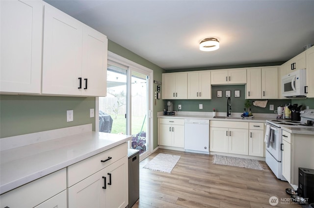 10103 Kline St SW, Lakewood, WA 98499 - kitchen featuring white appliances, a sink, white cabinets, light countertops, and light wood-type flooring
