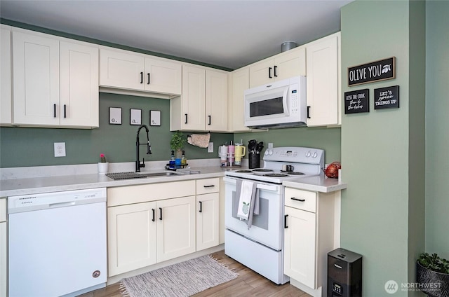 10103 Kline St SW, Lakewood, WA 98499 - kitchen featuring white appliances, a sink, light wood-style floors, white cabinets, and light countertops