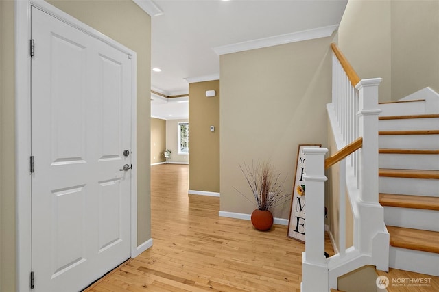 entrance foyer featuring light wood finished floors, baseboards, stairs, crown molding, and recessed lighting