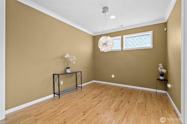 empty room featuring light wood finished floors, baseboards, and ornamental molding