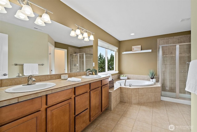 full bath with tile patterned floors, a sink, visible vents, and a shower stall