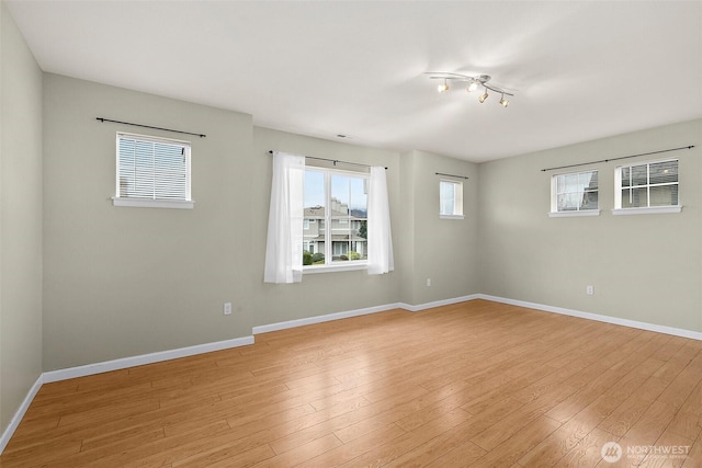 unfurnished room featuring baseboards and light wood finished floors