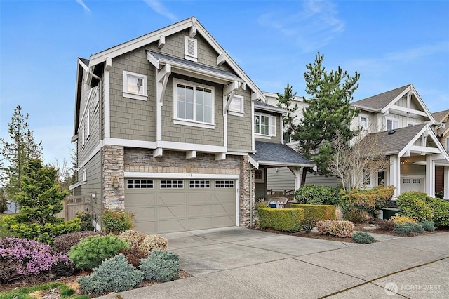 view of front facade with a garage, stone siding, and concrete driveway