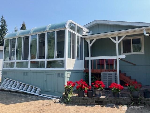 view of property exterior with a sunroom and cooling unit