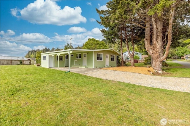 view of front of house with driveway, a front yard, and fence