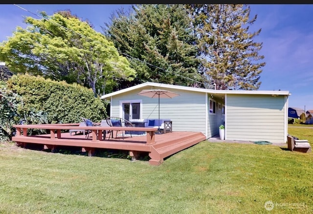 back of property featuring a deck and a yard