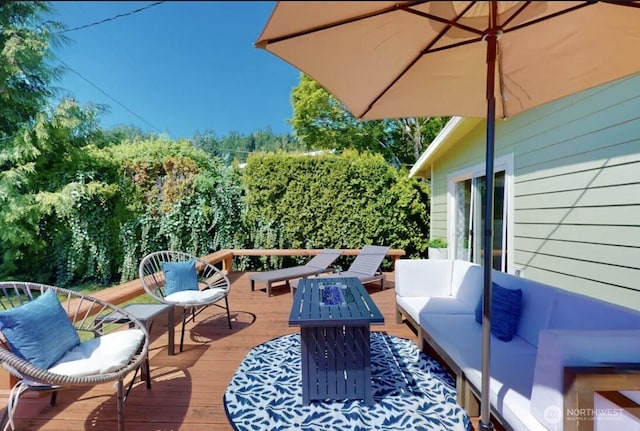 wooden terrace featuring an outdoor living space with a fire pit