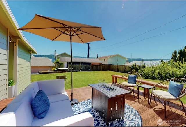 view of patio / terrace featuring fence, a deck, and an outdoor living space with a fire pit