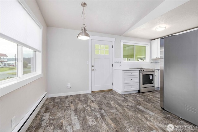 kitchen with dark wood finished floors, a baseboard heating unit, stainless steel appliances, and a wealth of natural light