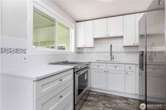 kitchen featuring tasteful backsplash, appliances with stainless steel finishes, dark wood-type flooring, white cabinetry, and a sink