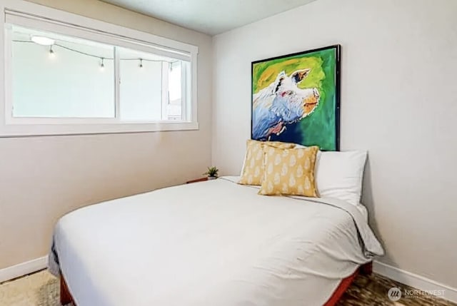 bedroom with wood finished floors and baseboards