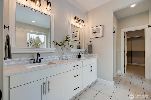 bathroom with decorative backsplash, marble finish floor, and a sink
