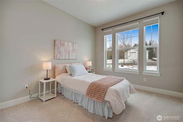 bedroom featuring light carpet and baseboards