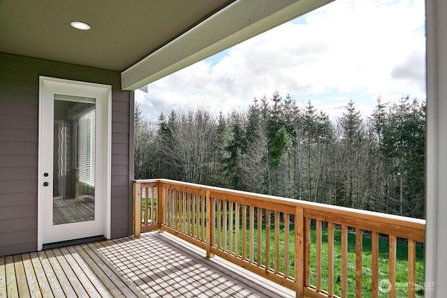 wooden terrace featuring a lawn