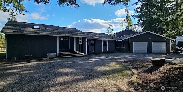 ranch-style house featuring gravel driveway and an attached garage