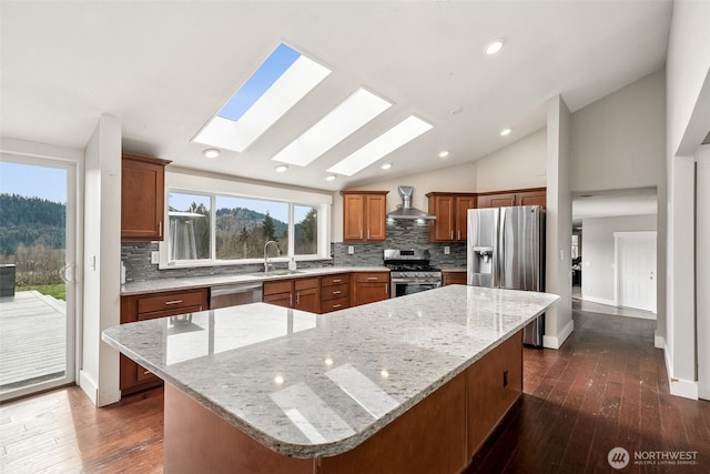 kitchen featuring a spacious island, vaulted ceiling, dark wood-style flooring, stainless steel appliances, and a sink