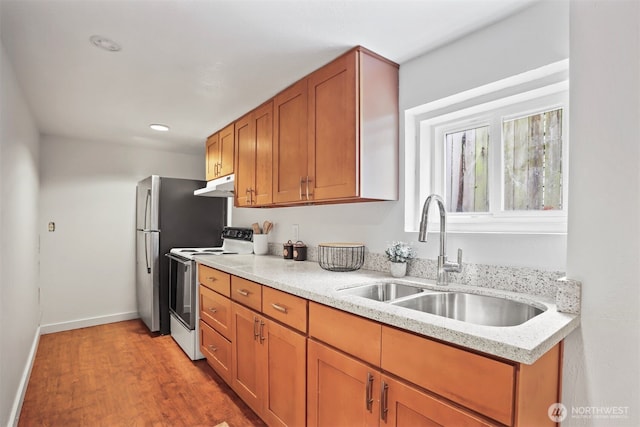 kitchen with light wood finished floors, brown cabinets, white electric range, under cabinet range hood, and a sink