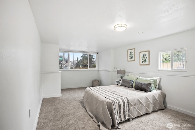 bedroom featuring carpet floors, multiple windows, and baseboards