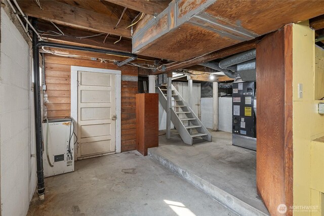 unfinished basement with stairs and washer / dryer