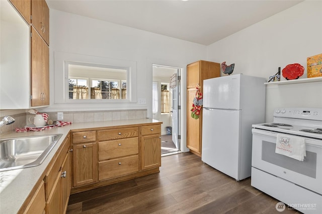 kitchen with white appliances, light countertops, a sink, and dark wood-style flooring