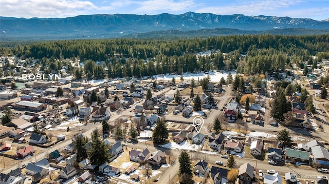 drone / aerial view with a forest view, a residential view, and a mountain view