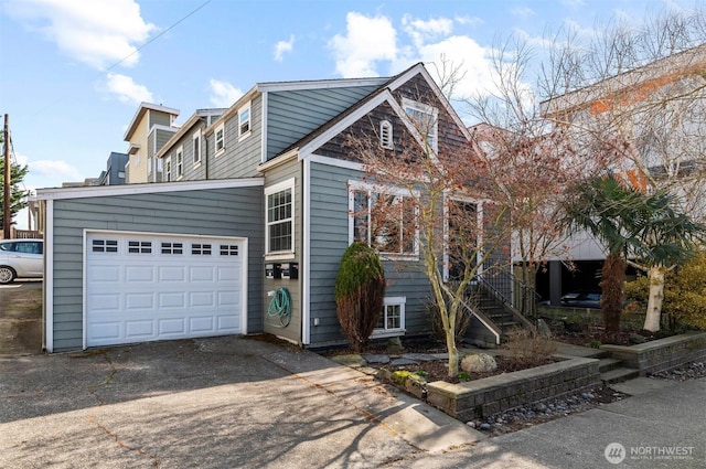 view of front facade featuring a garage, concrete driveway, and stairway