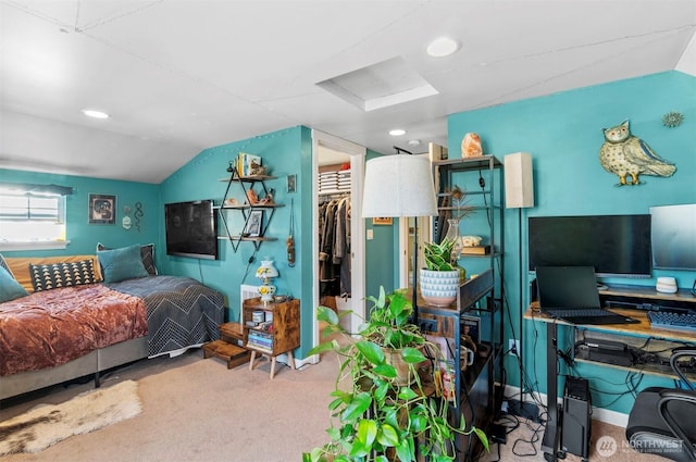 bedroom with attic access, carpet, vaulted ceiling, and a spacious closet